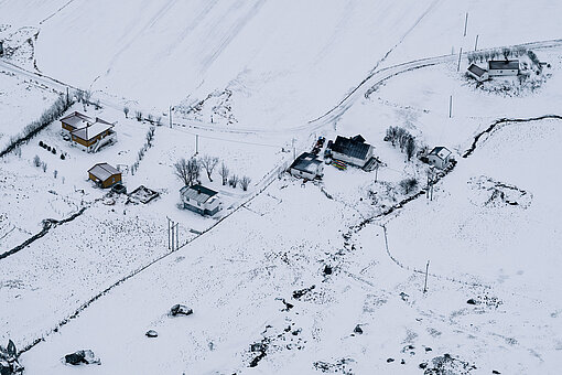Snow-covered houses and fields.